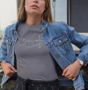 Camiseta cinza Blue Axis da Latitude23 com design minimalista 23S e símbolo de bússola, usada por mulher com jaqueta jeans aberta em estilo casual moderno.