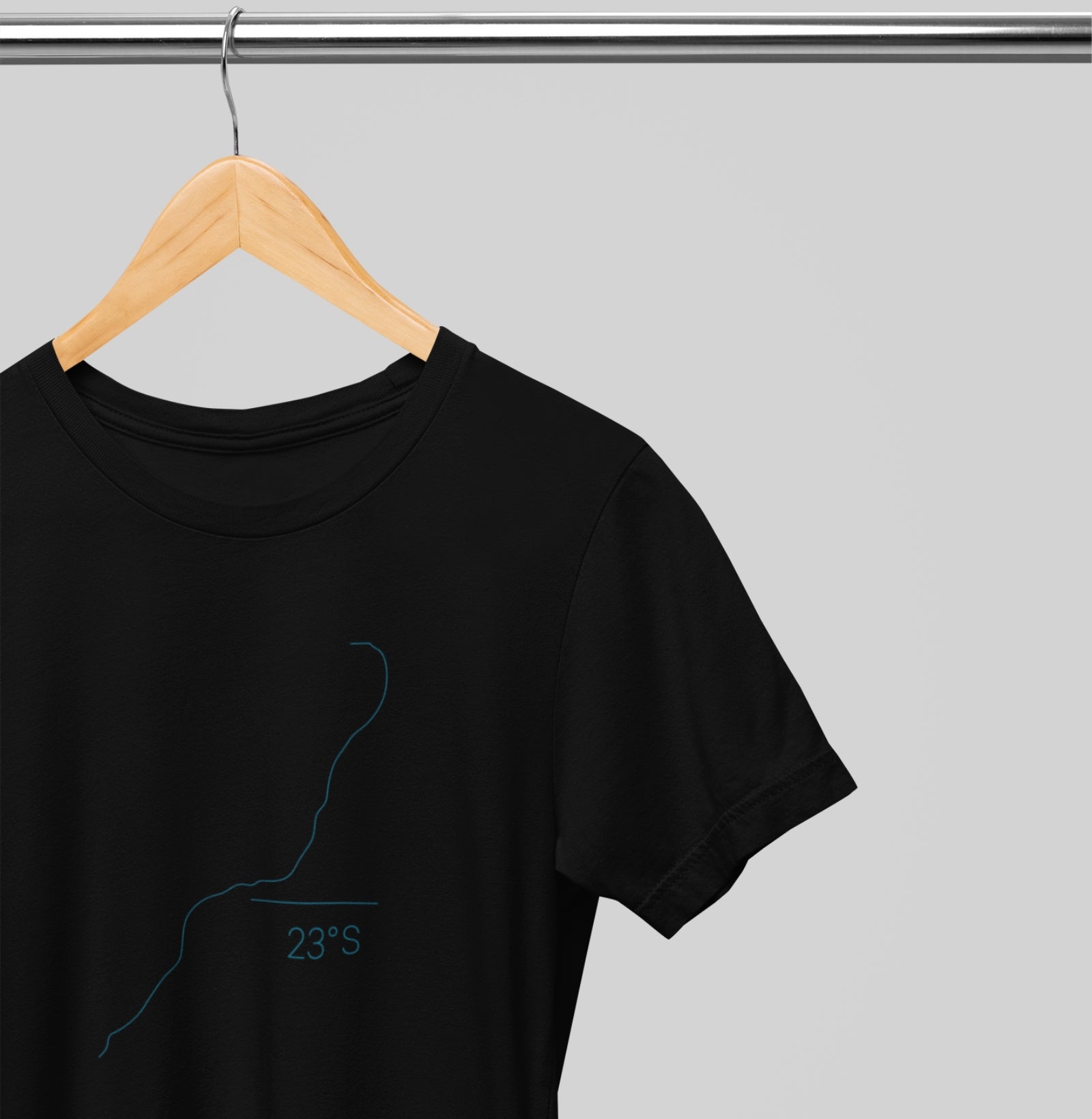 Camiseta preta Coastal Line da Latitude23 pendurada em cabide, com design minimalista da costa e coordenada 23S, inspirada na elegância do estilo náutico.
