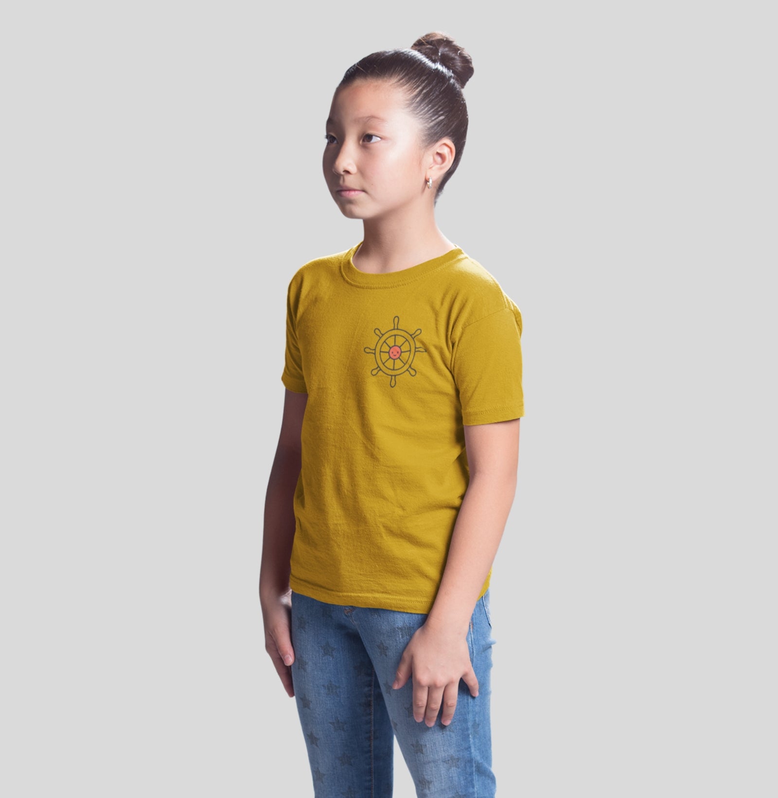 Camiseta infantil amarela First Tide da Latitude23, com estampa de leme náutico no peito, feita para crianças que carregam o espírito livre do mar.
