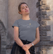 Camiseta cinza Horizon 23°S da Latitude23 com design minimalista de linha do horizonte, sol dourado e coordenada 23°S, usada por mulher em ambiente urbano iluminado.