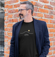 Homem usando camiseta preta Line Twenty-Three da Latitude23 com blazer azul, em ambiente urbano, exibindo estampa 23°S minimalista que simboliza o equilíbrio do sul.