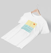 Camiseta branca Ocean Frame da Latitude23 pendurada em cabide, com estampa de listras coloridas, sol alaranjado e veleiro verde, inspirada no estilo náutico moderno.