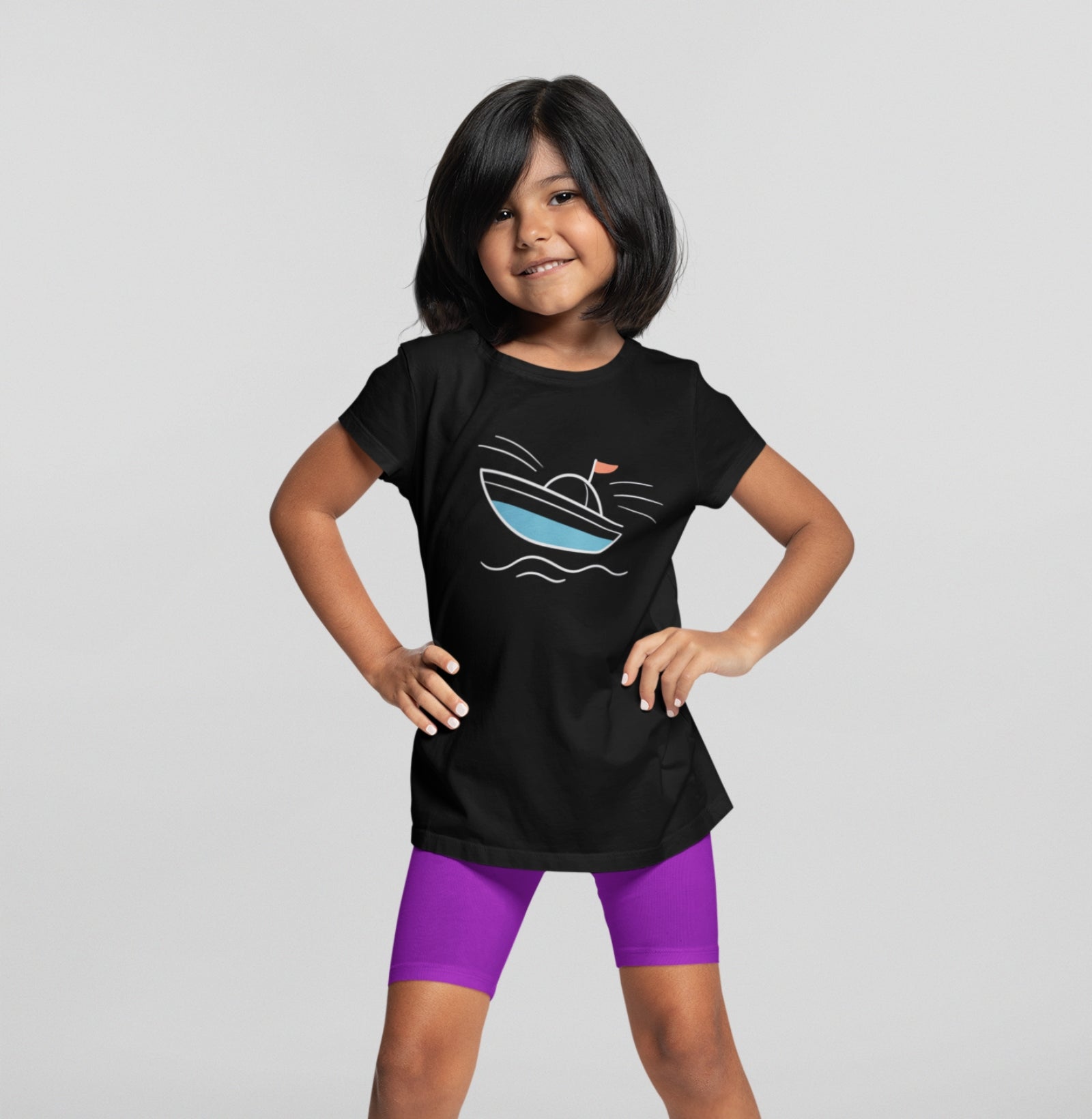 Menina sorrindo com camiseta preta Open Horizon da Latitude23, exibindo estampa minimalista de barco azul com bandeira vermelha, inspirada no universo náutico.
