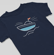 Detalhe da camiseta azul marinho Open Horizon da Latitude23, com estampa minimalista de barco em azul e vermelho, simbolizando liberdade e o espírito do mar.